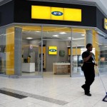 A worker sweeps past an outlet of South Africa’s MTN Group in Johannesburg
