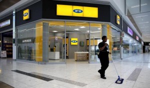 A worker sweeps past an outlet of South Africa’s MTN Group in Johannesburg