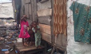 Children possing in front of one of the shanties in Otto