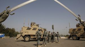 U.S. soldiers wait before going out on a mission, under the “Crossed-Sabers” in Baghdad