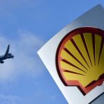 File photo of passenger plane flies over a Shell logo at a petrol station in west London
