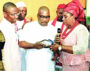 eric-osagie-receiving-award-of-excellence-from-chief-adimachukwu-calista-mmilioma-while-others-watch-with-admiration