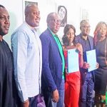 • Simi (center) displaying the contract and Etisalat staff