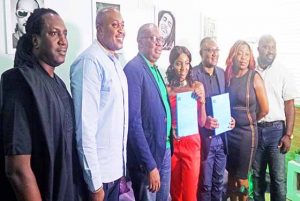 • Simi (center) displaying the contract and Etisalat staff