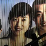 People pass by a billboard in the financial district of Shanghai