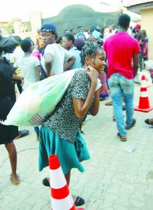 One of the beneficiaries ferrying her food items away at the Jubilee Food and Charity Day