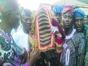 Olawayi Masquerade flanked by the custodian, Chief Sunday Olubodun and his son, Akeem