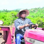Dr. Kalu driving a tractor in the farm