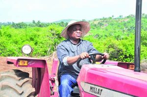 Dr. Kalu driving a tractor in the farm