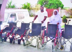 HILARY OKECHUKWU WITH A SISTER DISPLAYING THE WHEEL CHAIRS.