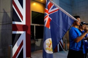 FILE PHOTO: A campaigner carries a former colonial Hong Kong flag while demanding Hong Kong-UK reunification protest outside the British Consulate in Hong Kong