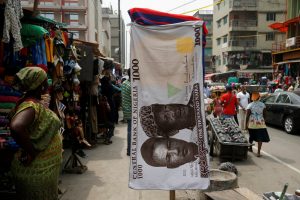 A towel with a print of the Nigerian naira is displayed for sale at a street market in the central business district of Lagos