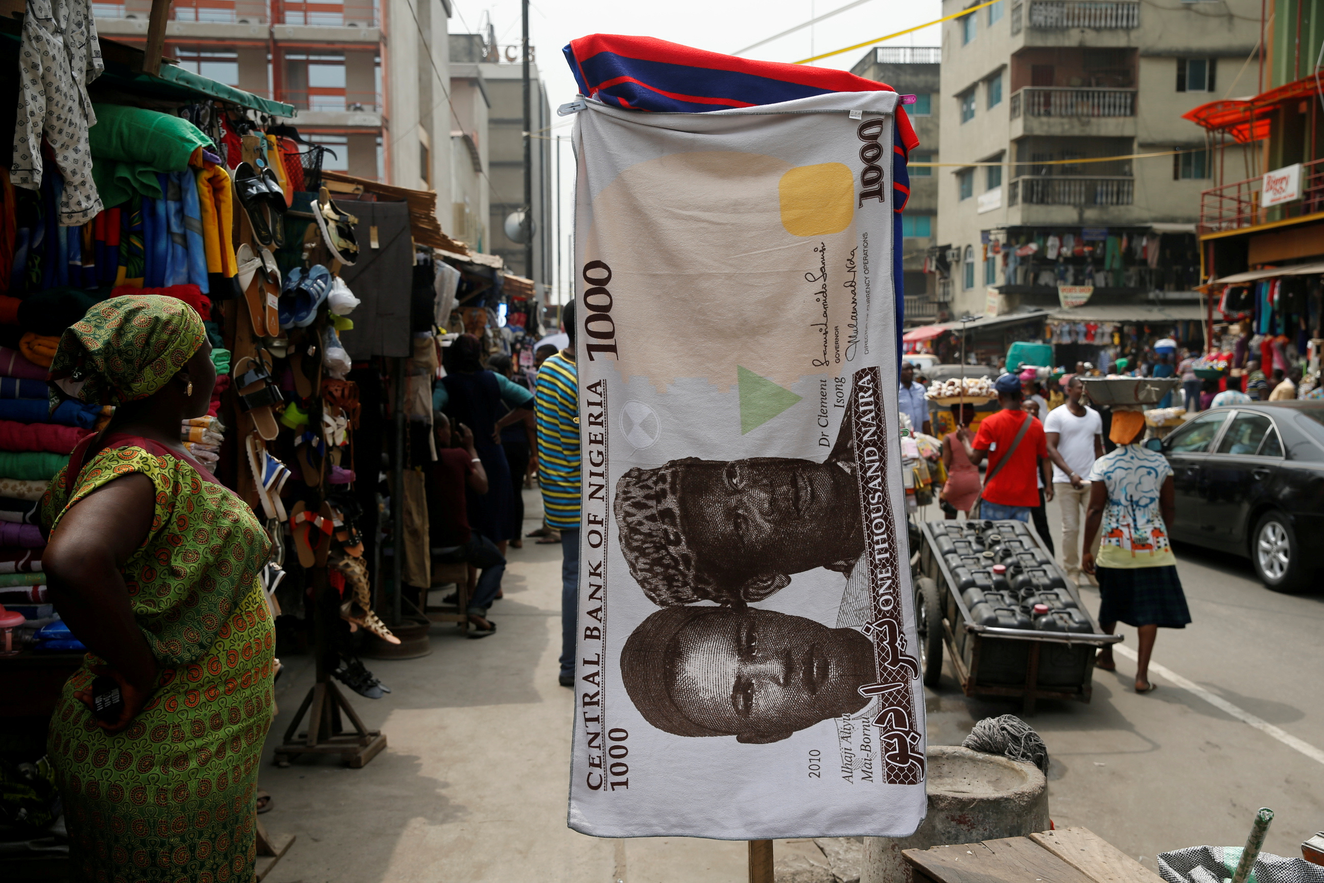 A towel with a print of the Nigerian naira is displayed for sale at a street market in the central business district of Lagos