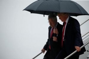 Trump holds an umbrella over Branstad as they arrive together aboard Air Force One at Eastern Iowa Airport in Cedar Rapids, Iowa