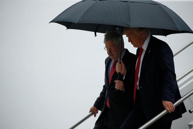 Trump holds an umbrella over Branstad as they arrive together aboard Air Force One at Eastern Iowa Airport in Cedar Rapids, Iowa