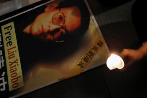 A protester holds a candle next to a portrait of Chinese Nobel rights activist Liu Xiaobo demanding his release, during Chinese President Xi Jinping visiting, ahead of 20th anniversary of the city’s handover from British to Chinese rule, in Hong Kong