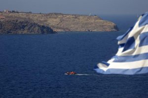 A dinghy overcrowded with migrants and refugees approaches the island of Lesbos