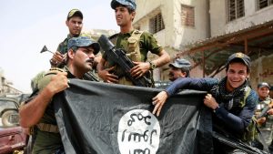 Iraqi Federal Police members hold an Islamic State flag, which they pulled down during fighting between Iraqi forces and Islamic State militants, in the Old City of Mosul