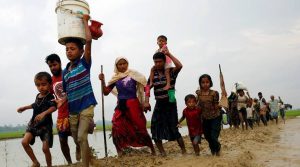 Rohingya refugees walk on the muddy path after crossing the Bangladesh-Myanmar border in Teknaf