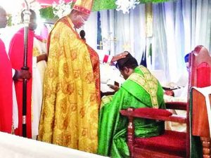 Bishop Nwokolo laying hands on Ven. Odita during the installation as Archdeacon of Omagba Archdeaconry