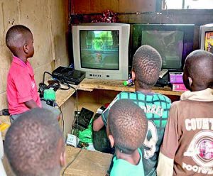 Children playing ‘God of War’ on a PlayStation 2 in a small gaming center in Badia, a Lagos slum