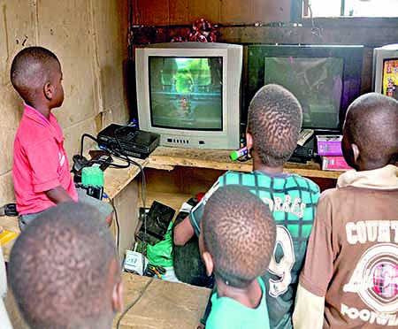 Children playing ‘God of War’ on a PlayStation 2 in a small gaming center in Badia, a Lagos slum