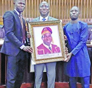 Outgoing VC, Unilag,Akoka, Prof Rahamon Bello receiving a plaque from Education Writers Association of Nigeria (EWAN), President, Bosun Ogundare and Secretary, Mojeed Alabi at the Senate Chambers