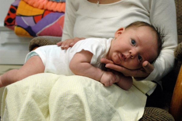 Burping baby lying across knees