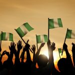 Group of People Waving Flag of Nigeria in Back Lit
