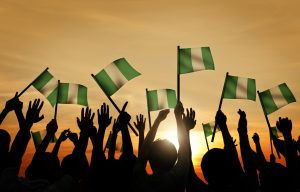 Group of People Waving Flag of Nigeria in Back Lit