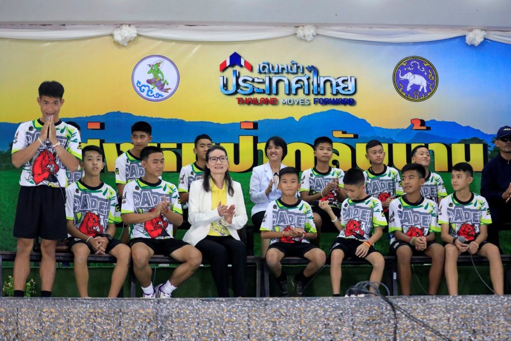 The 12 boys and their soccer coach who were rescued from a flooded cave arrive for a news conference in the northern province of Chiang Rai