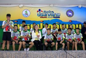 The 12 boys and their soccer coach who were rescued from a flooded cave arrive for a news conference in the northern province of Chiang Rai