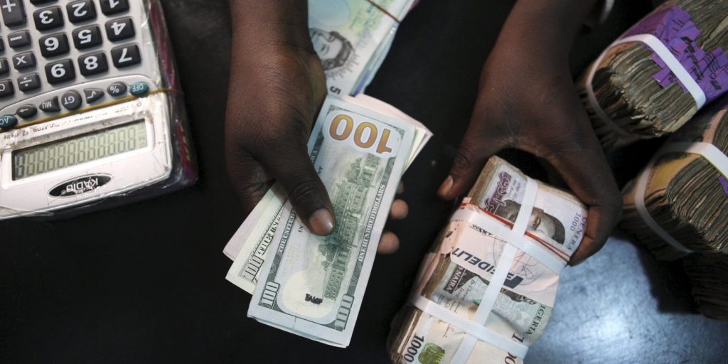 File photo of a trader changing dollars with naira at a currency exchange store in Lagos