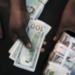 File photo of a trader changing dollars with naira at a currency exchange store in Lagos
