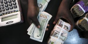 File photo of a trader changing dollars with naira at a currency exchange store in Lagos