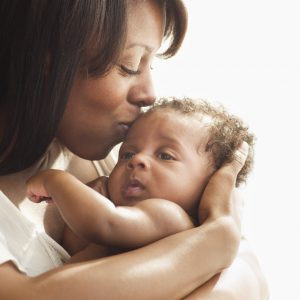 Mother kissing and hugging baby