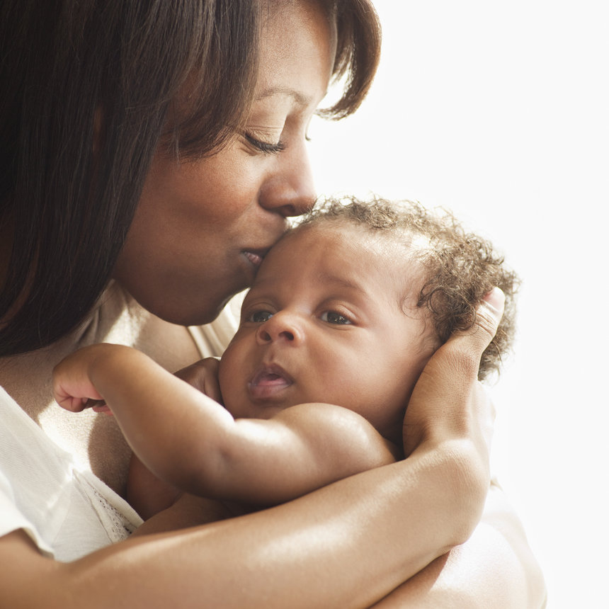 Mother kissing and hugging baby