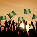 Group of People Waving Flag of Nigeria in Back Lit