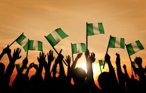 Group of People Waving Flag of Nigeria in Back Lit