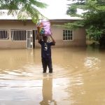 Man removing items from submerged house