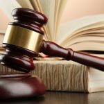 wooden gavel and books on wooden table,on brown background