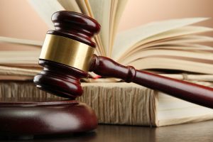 wooden gavel and books on wooden table,on brown background