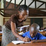 A-teacher-assistijng-a-student-in-a-UNICEF-supported-school-in-Ganta-Town-Liberia