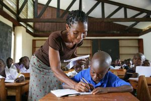 A-teacher-assistijng-a-student-in-a-UNICEF-supported-school-in-Ganta-Town-Liberia