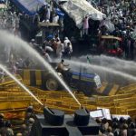 Police use water cannons to disperse farmers during a protest demanding better price for their produce on the outskirts of New Delhi