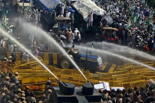 Police use water cannons to disperse farmers during a protest demanding better price for their produce on the outskirts of New Delhi