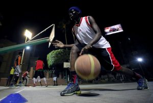 A Sudanese refugee dribbles the ball during a basketball game in Cairo