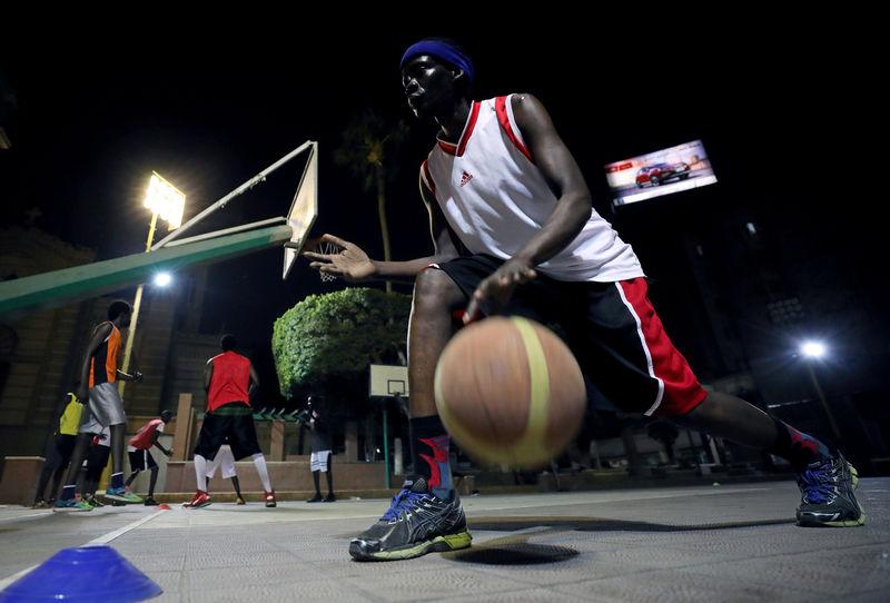 A Sudanese refugee dribbles the ball during a basketball game in Cairo
