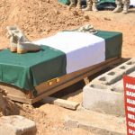 Boots and cap of a soldier laid on a coffin