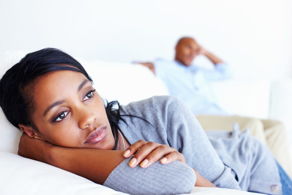 Unhappy woman lying in couch